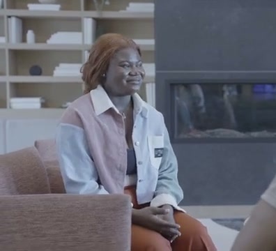 Nia with ginger hair talking with David by a fireplace in Grace In Disguise